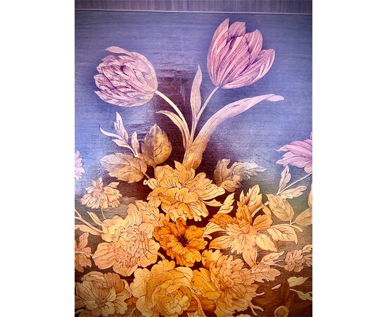 Pannello in legno intarsiato con decoro a vaso di fiori e frutta.