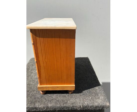 Model of sweet wood chest of drawers with bamboo details and marble top.     