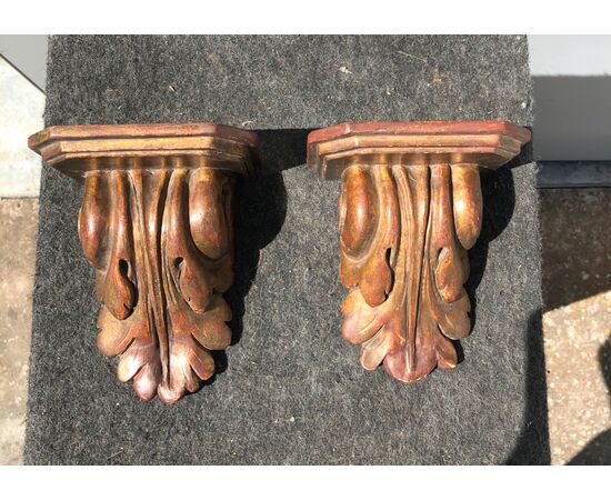 Pair of shelves in lacquered and gilded wood with stylized leaf decoration.     