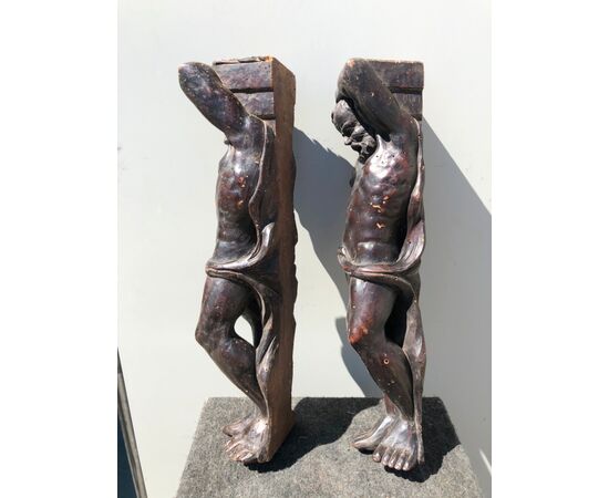 Coppia di fregi-sculture in legno di noce con figure maschili.