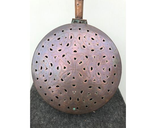 Copper warmer with engraved geometric patterns. Wooden handle.     