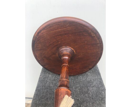 Round table in walnut with central leg and three feet.     