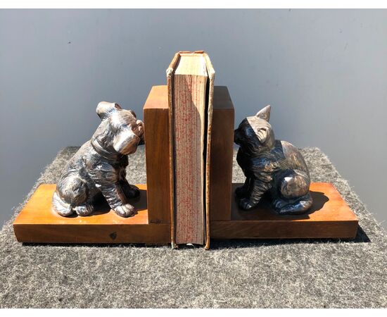 Coppia di fermalibri in metallo e legno raffiguranti cane e gatto.
