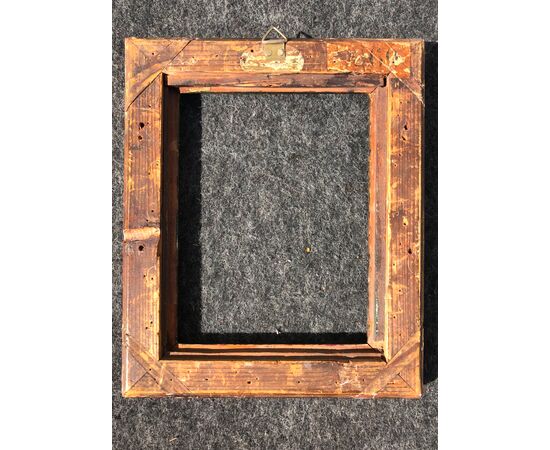 Carved and gilded wooden frame with stylized plant motifs and rocaille and knurling.     