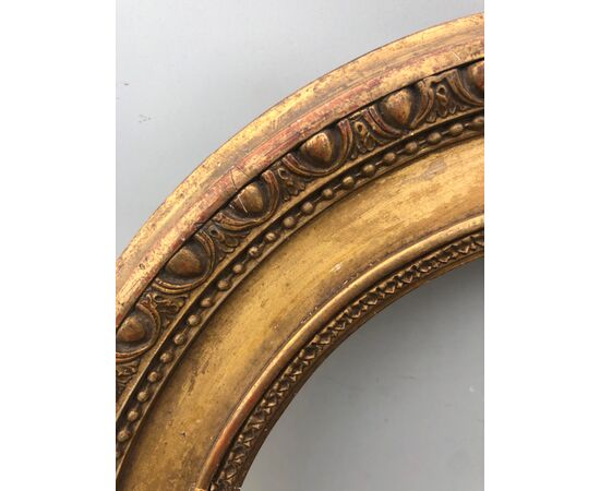 Frame in carved wood and gold leaf with geometric motifs.     
