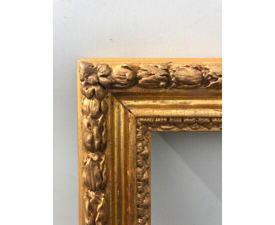Carved wooden frame with bulbs and gold leaf.     