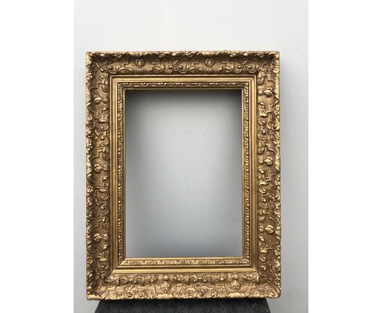 Carved and gilded wooden frame with vegetable and geometric motifs in tablet.     