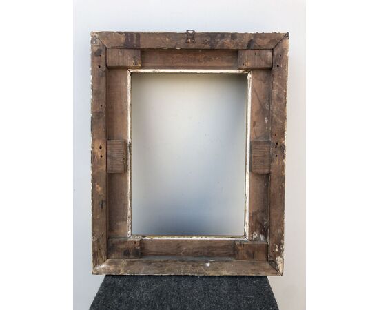 Carved and gilded wooden frame with vegetable and geometric motifs in tablet.     