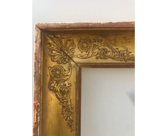Carved and gilded wooden frame with rocaille details and Marian symbols in pastille.     