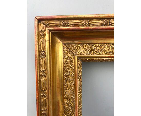 Frame in carved wood and gold leaf with plant and rocaille motifs.     