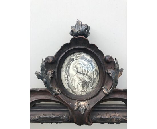 Double-sided carved wooden frame with silver details and coping with print and painting on glass depicting St. Luigi Gonzaga.     