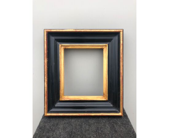 Pair of frames in carved, ebonized and gilded wood.     