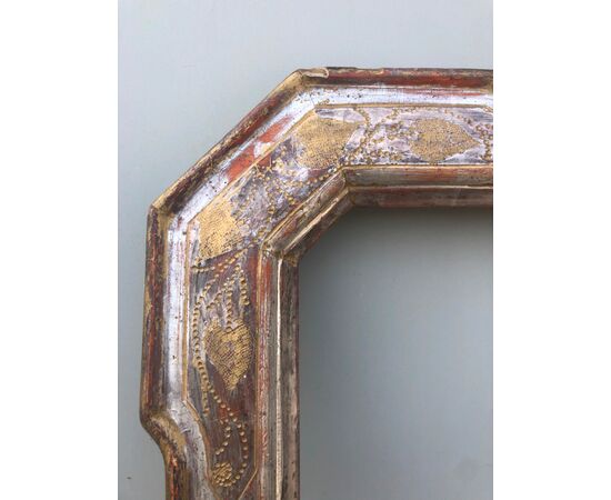 Cabaret frame in carved and silvered wood with golden stylized vegetal details.     