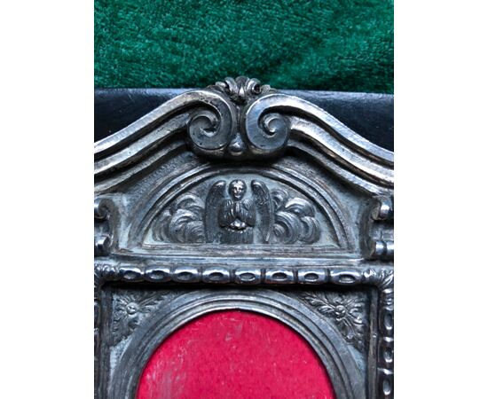‘Pace-edicola’in argento e lapislazzuli con decoro rocaille e angelo,montata a portaritratti su base di legno ebanizzato.Sicilia.