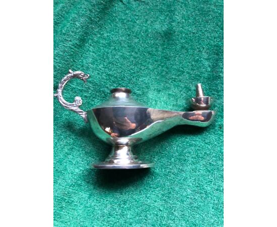 Small silver candlestick with a handle in the shape of a stylized dragon.     