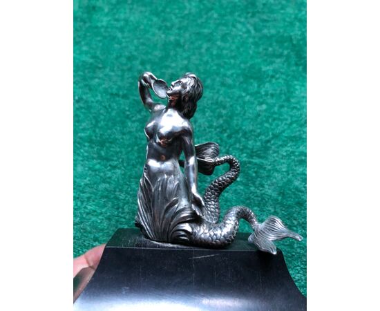 Figura di sirena in argento  con coda biforcuta che regge una conchiglia.Base in ebano.