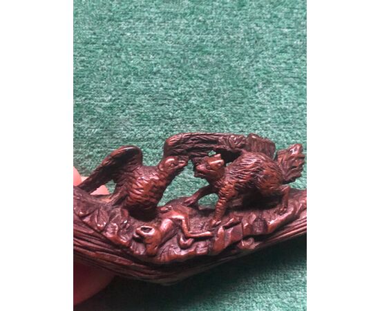 Carved wooden pipe depicting an eagle and a fox competing for a fawn as prey.     