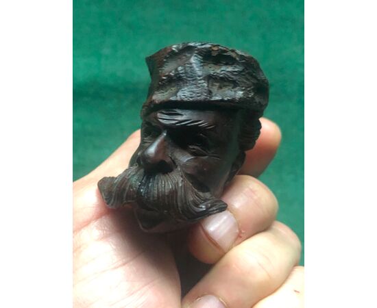 Carved wooden pipe depicting a mustachioed man with hat.     