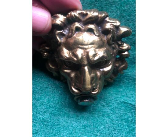 Bronze bell depicting a lion&#39;s head.     