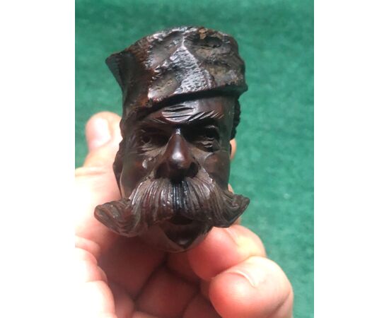 Carved wooden pipe depicting a mustachioed man with hat.     