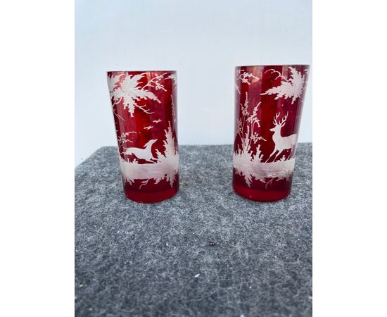Pair of bohemian glasses in cased glass with grinding wheel decoration depicting hunting scenes.     