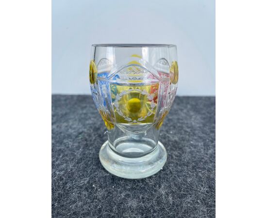 Bicchiere boemia in vetro incamiciato a tre medaglioni e tre colori con decoro alla mola raffigurante motivi floreali geometrici.