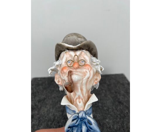 Scultura in porcellana policroma raffigurante testa di uomo con cappello e pipa.Giuseppe Cappe’.