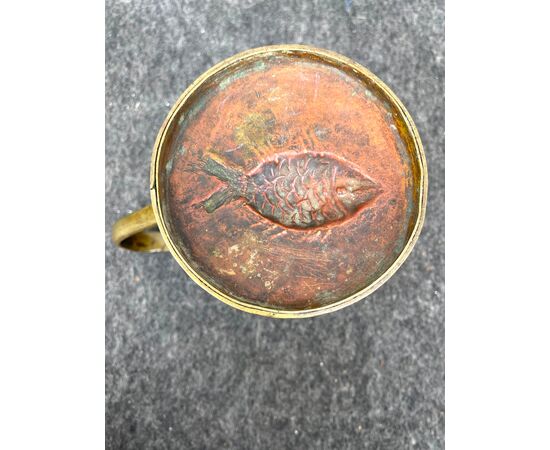 Bronze mug with fish-shaped mold on the bottom.     