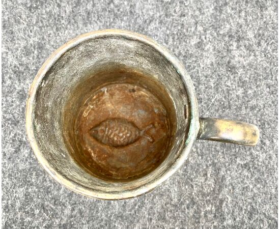 Bronze mug with fish-shaped mold on the bottom.     