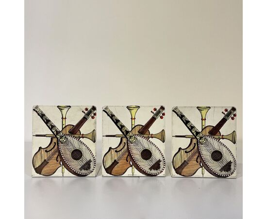 FORNASETTI, gruppo di tre fermalibri metallo bianco decoro strumenti musicali
