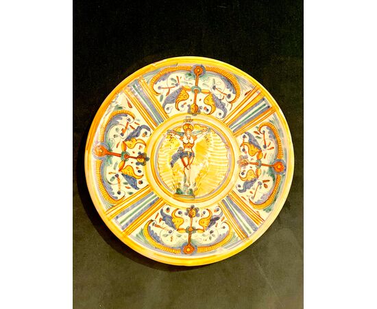Majolica platter-cutting board with Raphaelesque-style neighborhood decoration. Central round with the figure of Christ on the cross. Deruta manufacture.     