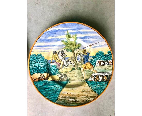 Pair of large majolica plates with historiated decoration.Manufacture of Ernesto Conti, Sesto Fiorentino.Tuscany.     