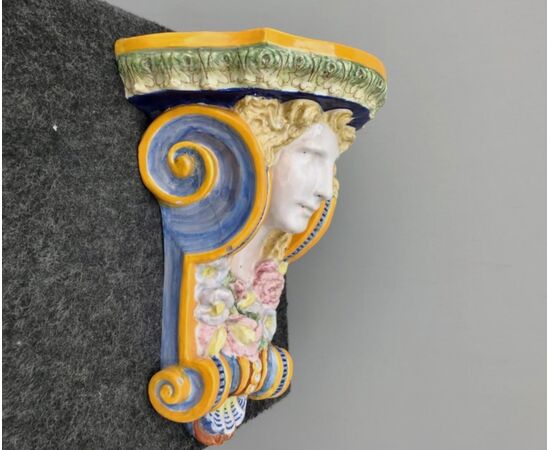 Majolica shelf with female face and art nouveau floral motifs.Minardi manufacture, Faenza.     