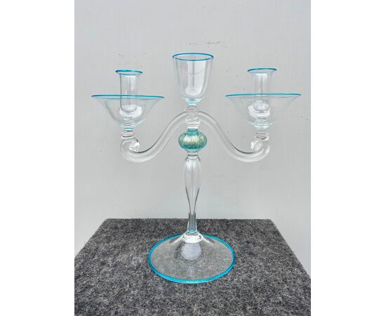 Slightly iridescent transparent glass candlestick with blue details.Presents a stylized human shape with two arms.Seguso manufacture.Murano.     