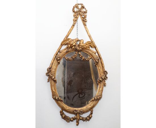 Pair of oval mirrors in gilded wood with a pair of birds     