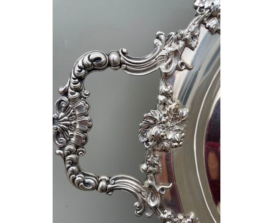 Large tray in silver plate with vine branch decorations and sockets with rocaille motifs.     