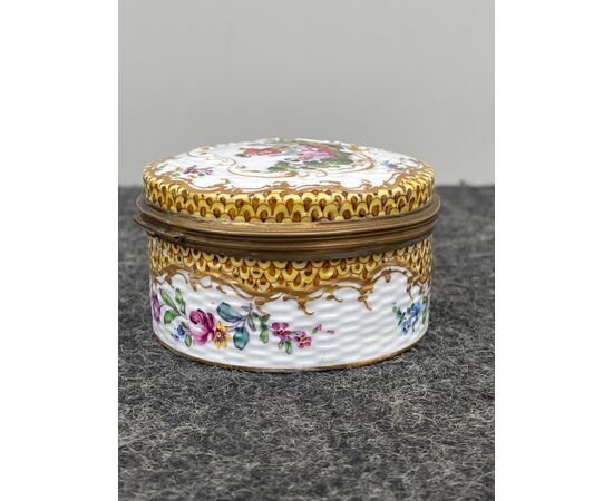 Porcelain box decorated with a gallant scene and floral and geometric motifs.Volute rocaille in relief.Signed by Edme&#39;Samson.France.     