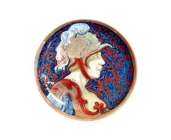 Majolica plate with metallic luster depicting the profile of a soldier with helmet and stylized vegetable decorations.Ginori manufacture.     