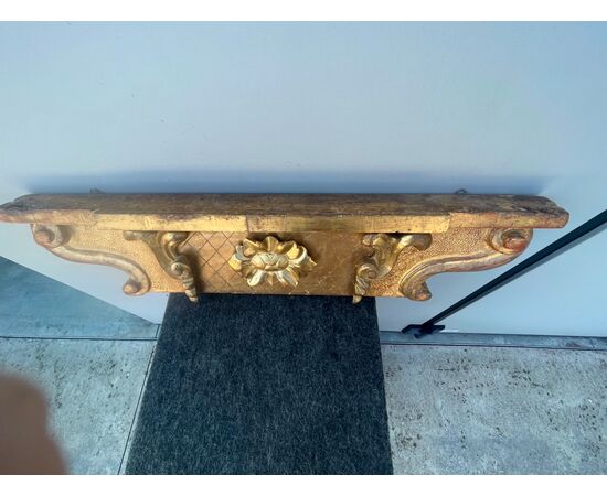 Applique shelf in carved wood and gold leaf with rocaille and floral decoration.     