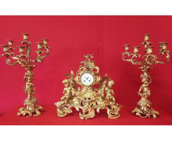 Orologio e Coppia di candelabri in bronzo dorato