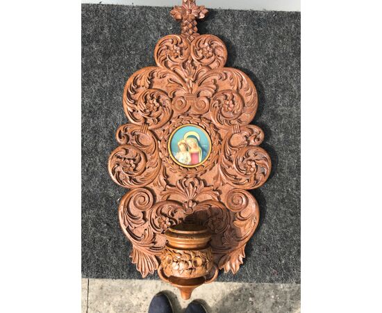 Holy water stoup in carved wood with vegetal stylized motifs and miniature on ivory Madonna with Child.     