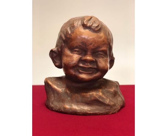 head of a child in terracotta. Signed     