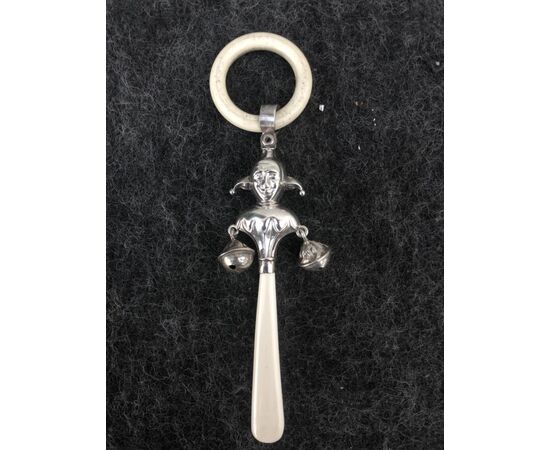 Silver baby rattle depicting a jolly and ivory handle. England.     