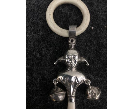 Silver baby rattle depicting a jolly and ivory handle. England.     