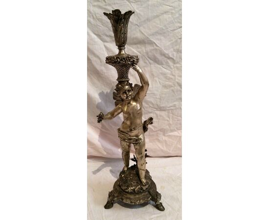 Nickel silver candlestick signed by the artist depicting cupid from the late 19th century