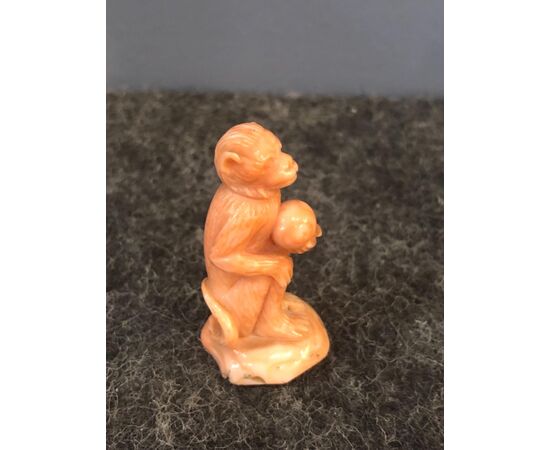 Small coral sculpture depicting a monkey holding a globe.Sciacca, Sicily.     