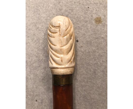 Stick with bone knob depicting skull with hood and beard.     