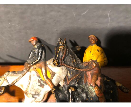 Scultura in bronzo raffigurante gruppo di personaggi a cavallo.