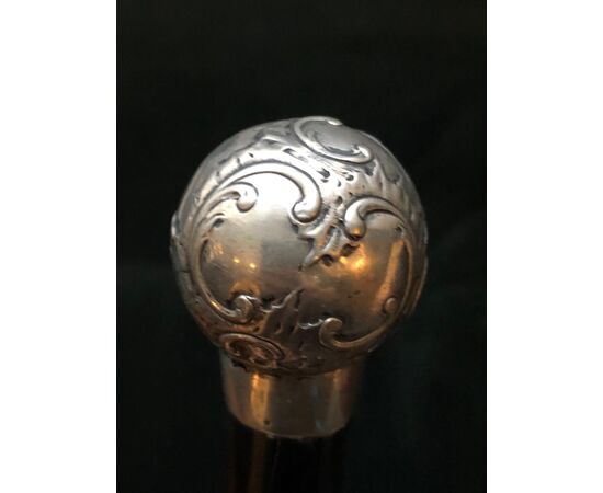 Round silver stick with knob with rocaille and floral motifs.     