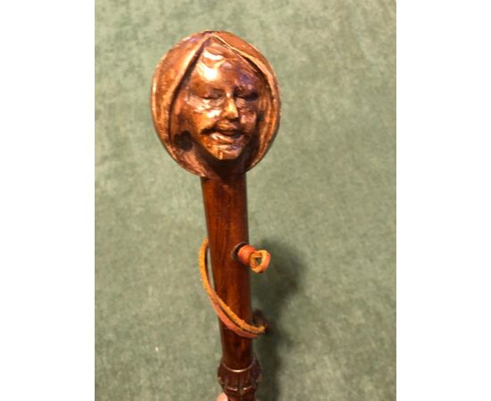 Stick with wooden knob depicting the head of a female figure.     